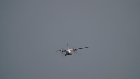 twin engine aircraft banking in clear blue sky with propellers spinning