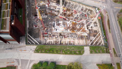 aerial view of a bustling construction site adjacent to a serene urban park