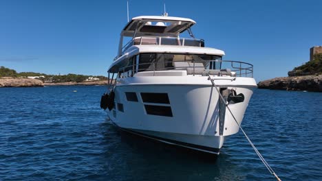 Slow-motion-drone-close-up-of-luxury-yacht-in-calm-bay-on-a-sunny-day