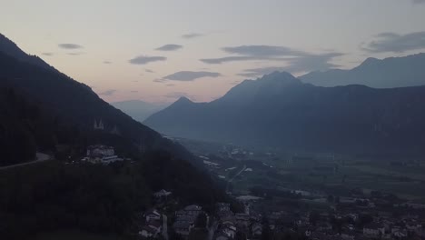 Aerial-view-of-Levico-Terme,-Italy-,-during-sunrise-with-drone-rising