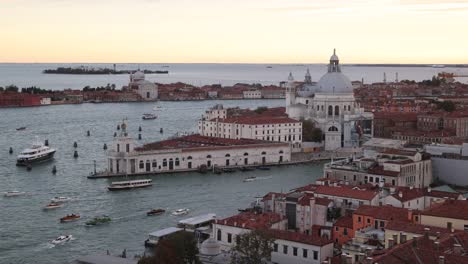 Venetian lagoon with boats passing historic buildings during a calm evening in Venice Italy
