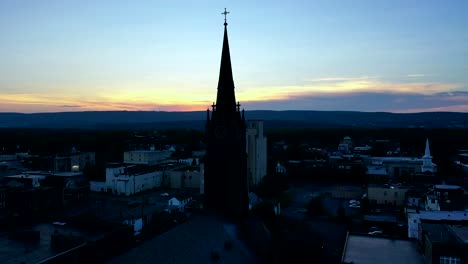 Zumbando-Hacia-El-Campanario-De-Una-Iglesia-Durante-Una-Puesta-De-Sol-En-Wilkes-barre,-Pennsylvania