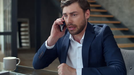Angry-businessman-talking-phone-at-home-office-emotionally.-Man-calling-phone.