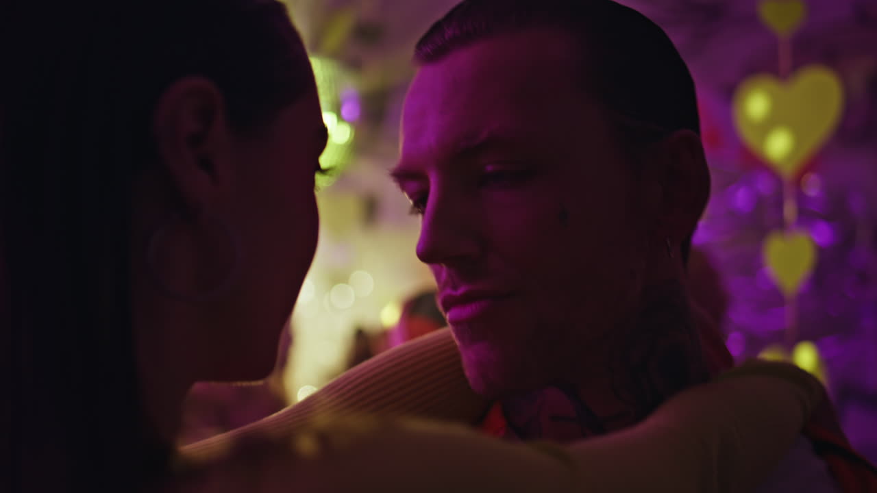 Couple youngsters enjoy party in club neon lights closeup. Intimate pair dancing