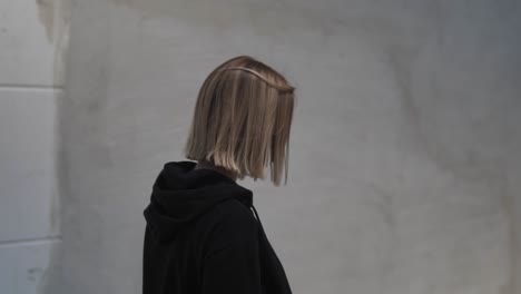 slow motion of young woman with face mask and black clothes walking in exterior