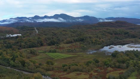 Retirada-Aérea-De-Tierras-De-Cultivo-Rurales-Con-Nubes-Bajas-Alrededor-De-Las-Montañas