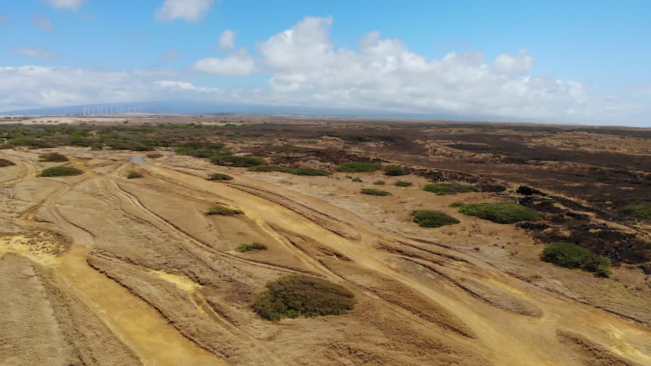 drone aéreo tiro 4k - isla de hawaii en un día ventoso con turbinas eólicas y volcán en el horizonte