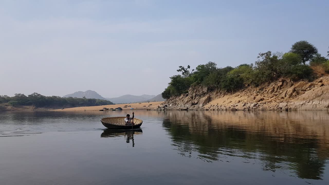 un hombre cruzando el río cauvery en un coracle en hogenakkal, tamilnadu, india