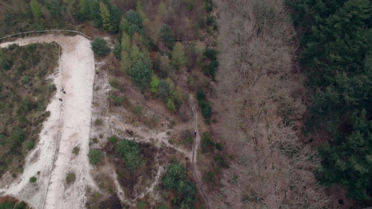 сверху вниз вид мотоцикла, движущегося по горной дороге в гасселте, гронинген, нидерланды - снимок с дрона