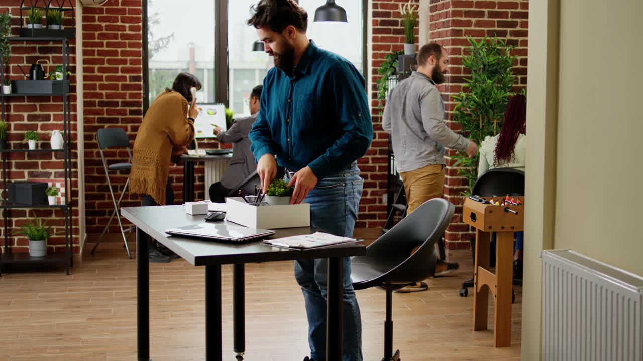Frustrated jobless man getting fired from work and packing belongings in box