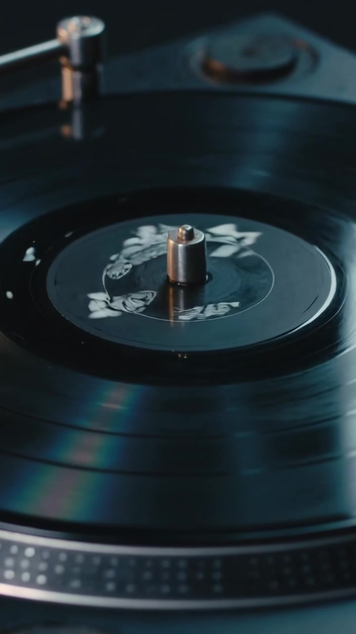Video verticale: Piatto rotante che aziona un disco in studio, trascinando vernice bianca in un anello su un perno.
