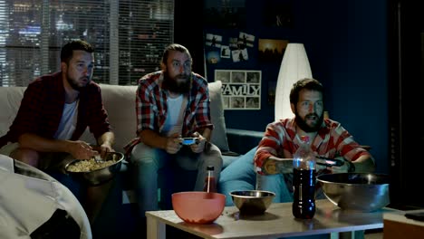 group of men play videogame together in evening