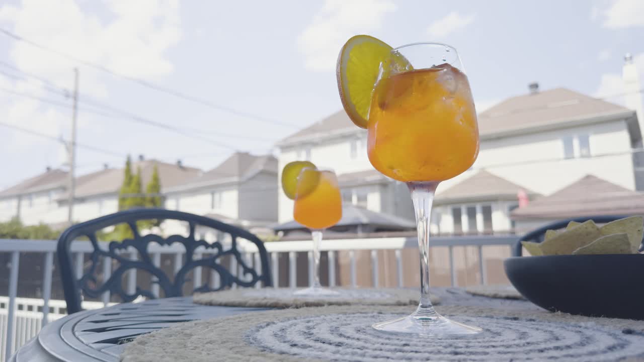 Low angle shot of a refreshing spritz being poured on a backyard patio set under a blue sky