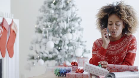 Young-African-woman-wrapping-gifts-at-Christmas