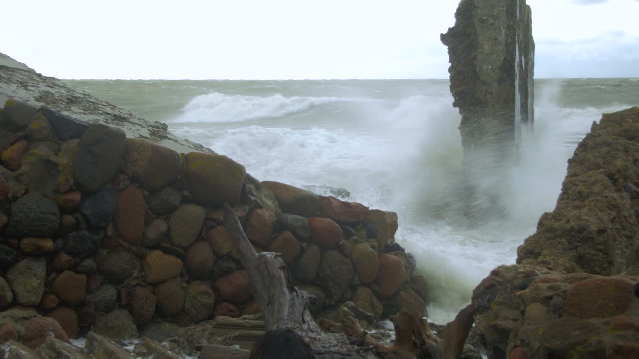 폭풍우에 버려진 콘크리트 해안 방어 건물 폐허를 강타하는 큰 파도