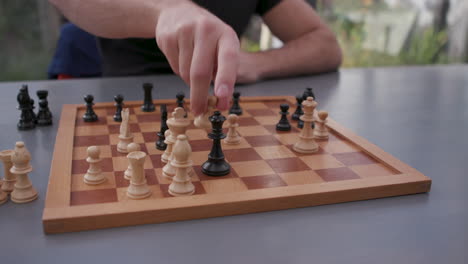 junger mann spielt schach am küchentisch