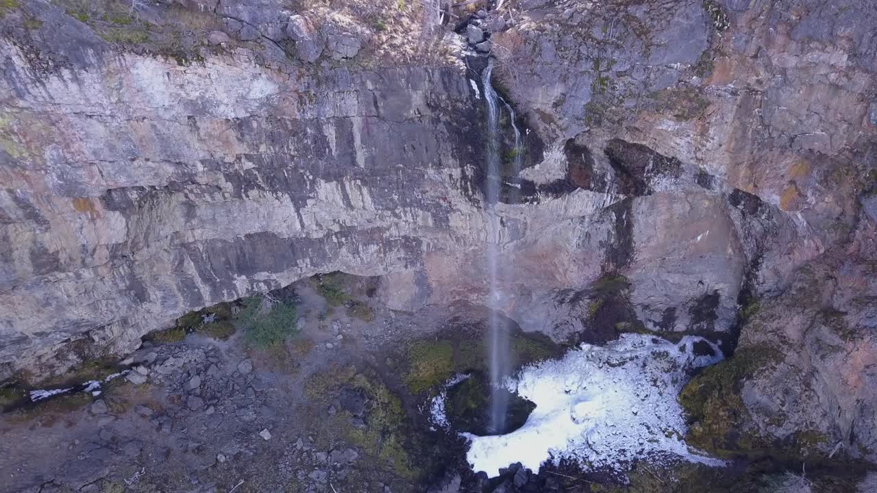 cascada delgada de 60 m con nieve y hielo en la base