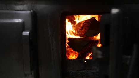 Slow-motion-fire-in-a-modern-oven,-with-some-wood-trunks