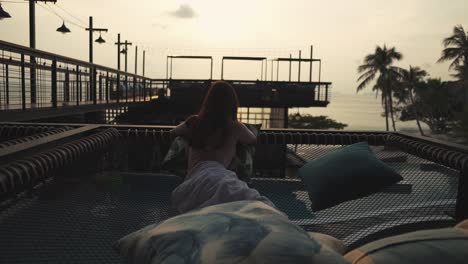 girl chill enjoy lie down in net hammock against sunset view