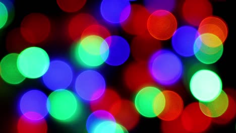 las luces bokeh azul-verde rojo y naranja parpadean y luego se apagan. luz de guirnalda eléctrica de color multicolor, concepto de año nuevo y vacaciones de navidad