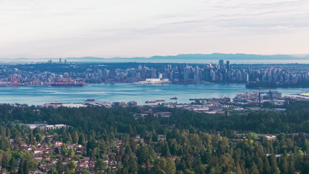 Ampio panorama dello skyline di Vancouver attraverso il porto di Vancouver, visto da Norwood Avenue a Burnaby, British Columbia, con area di lavoro alberata in primo piano e paesaggio urbano costiero
