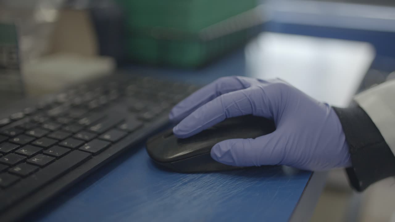 científico en laboratorio usando mouse para investigación informática con guantes a mano