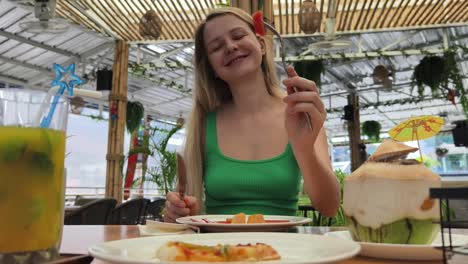 woman eating lunch at a tropical cafe