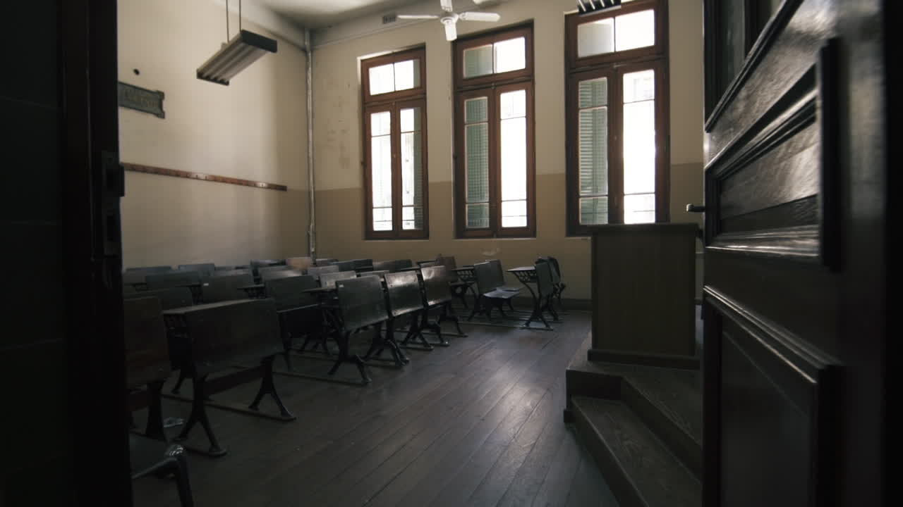 Aula scolastica vintage vuota con banchi in legno e finestre