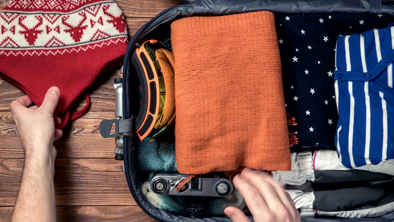 남자친구가 여자친구를 위해 겨울 휴가를 위해 짐을 고 있다.