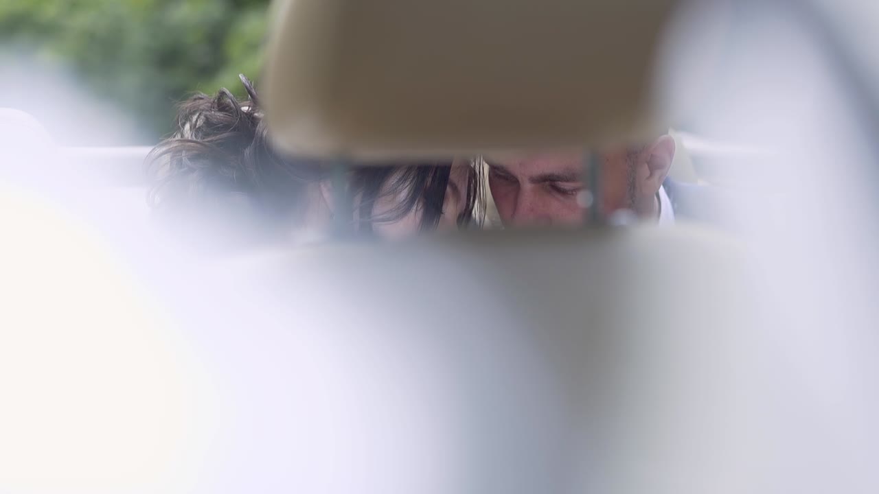 천천히 움직이는 멋진 결혼 부부가 뒷좌석에서 포옹합니다.