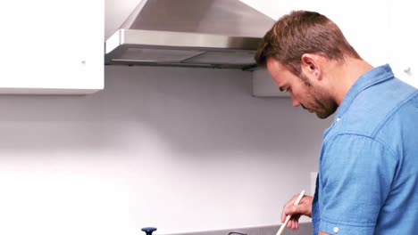 hombre guapo cocinando pastas en la cocina