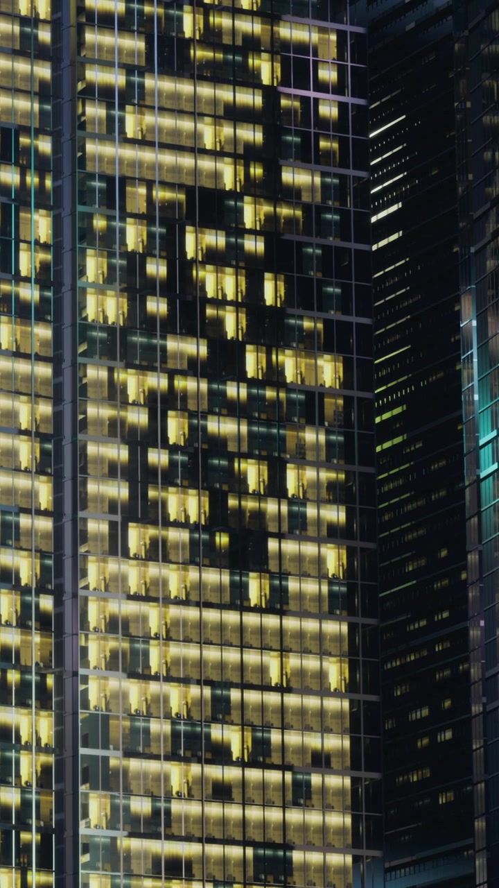 City lights glow on tall buildings at night in urban area