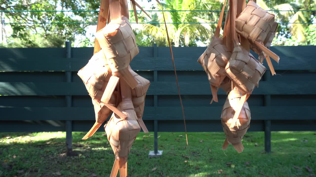 colgar ketupat para drenar el agua después de hervirlo. ketupat es un alimento especial durante las fiestas islámicas en indonesia