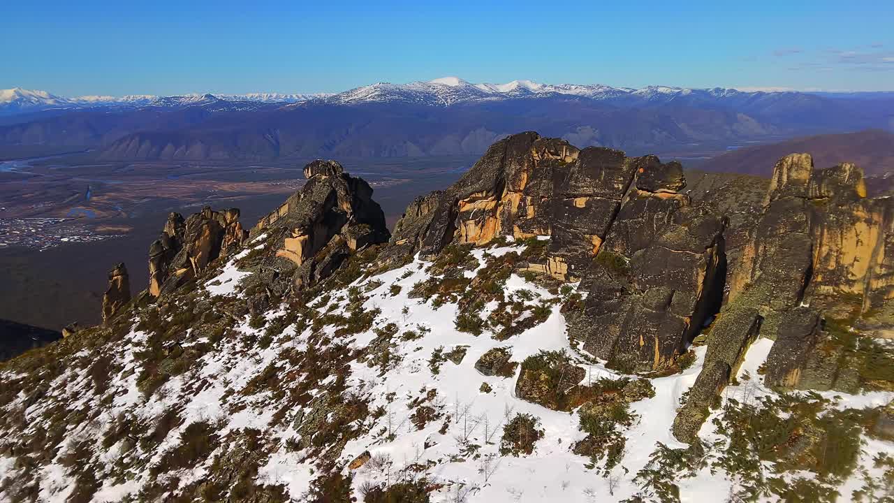 una montaña cubierta de nieve se destaca con otras montañas en el fondo bajo el cielo despejado
