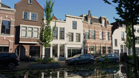 scene of canal houses at turfmarkt street in the old town of gouda, south holland, netherlands