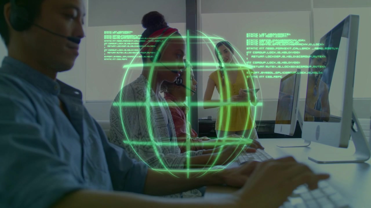 Operators typing in training room, lead observing, initiating green globe overlay displaying data