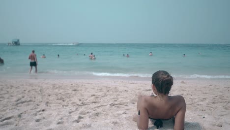 wonderful young woman admires blue ocean foaming waves