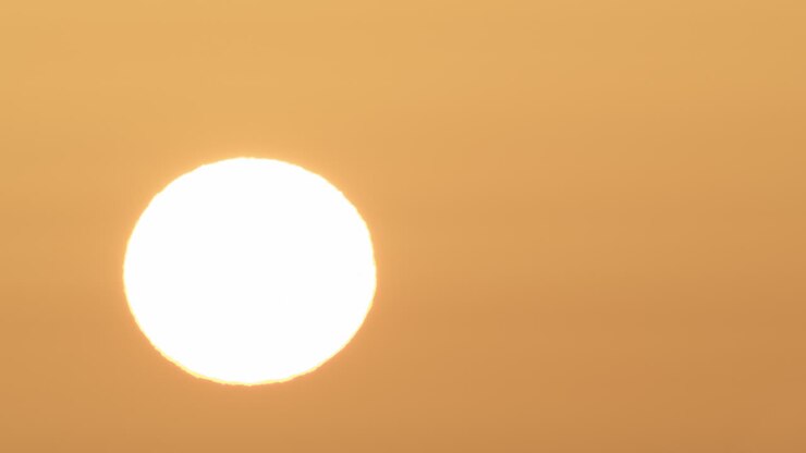 Bright disk of the sun in the sky at dawn