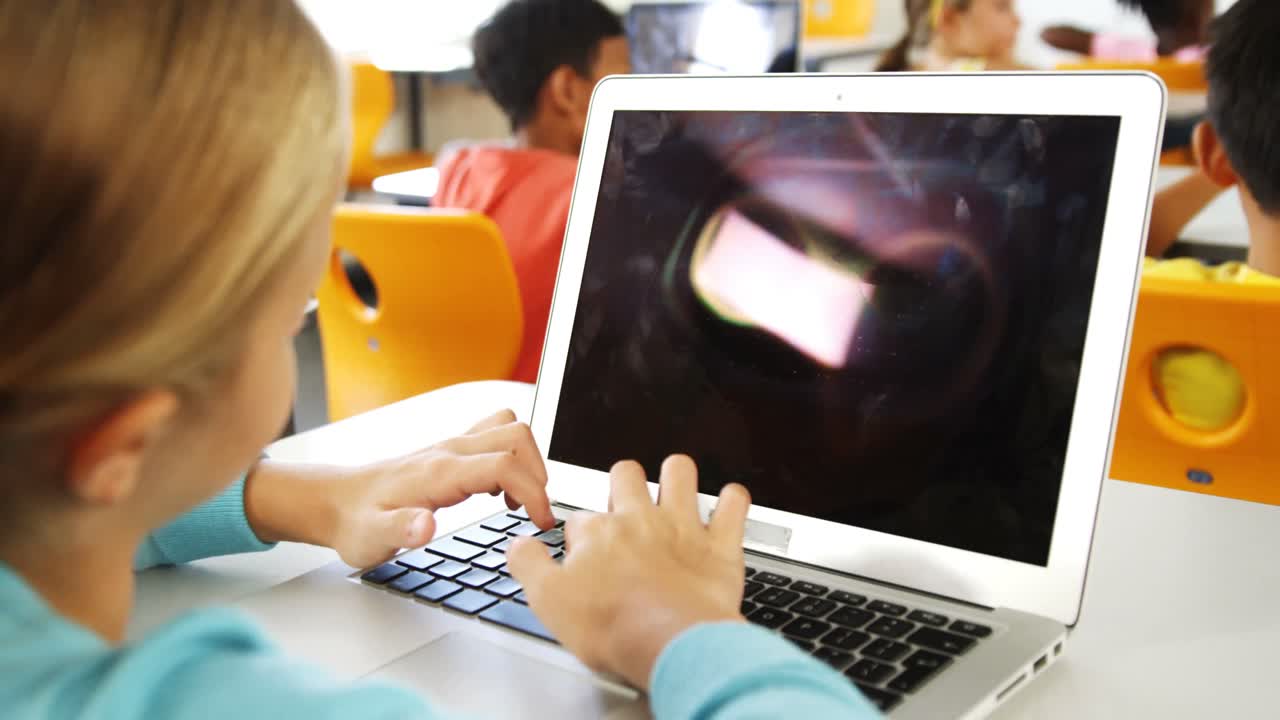 niña usando una computadora portátil en el aula