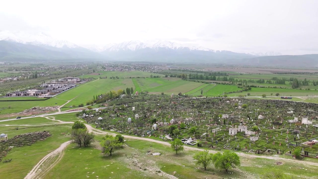 Panorama aereo con drone del Mausoleo di Baitik, monumento storico, e delle montagne a Bishkek, Kirghizistan.
