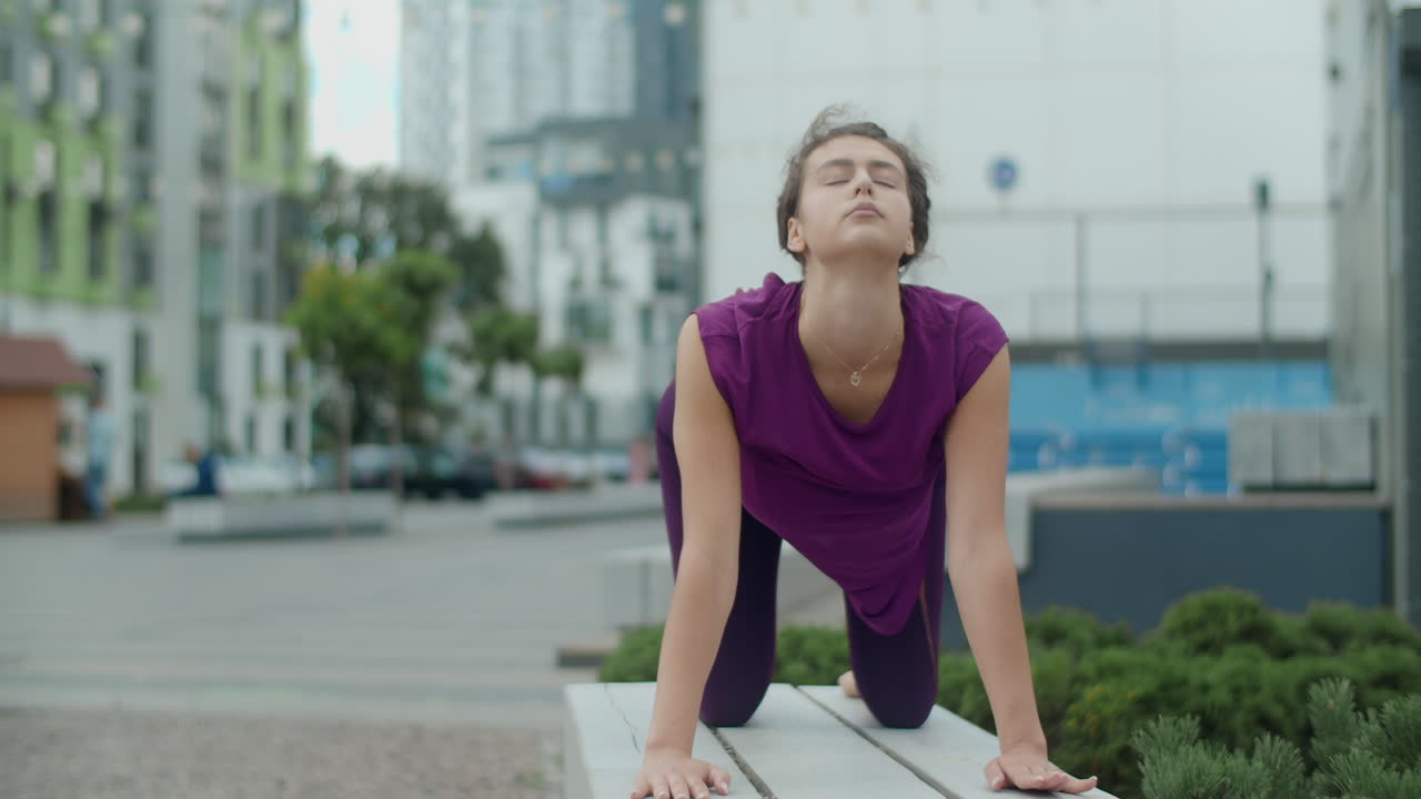 Woman practicing yoga in an urban park