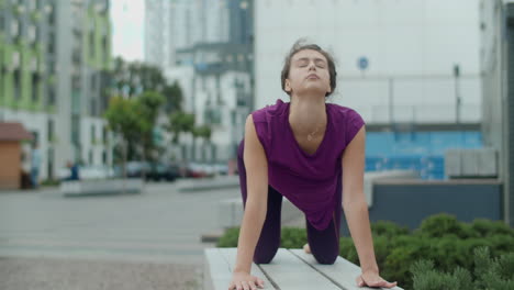 woman practicing yoga in an urban park