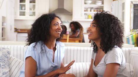 Mother-Talking-With-Teenage-Daughter-Sitting-On-Sofa-Together