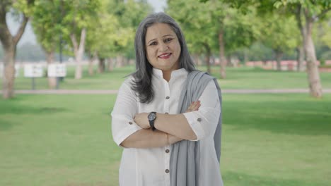 Happy-Indian-mother-standing-crossed-hands-in-park