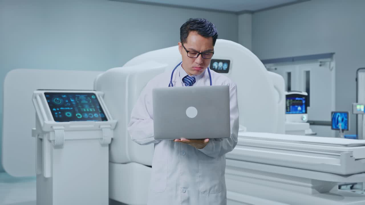Asian Male Doctor Having A Headache While Working On A Laptop With MRI Machine In The Hospital
