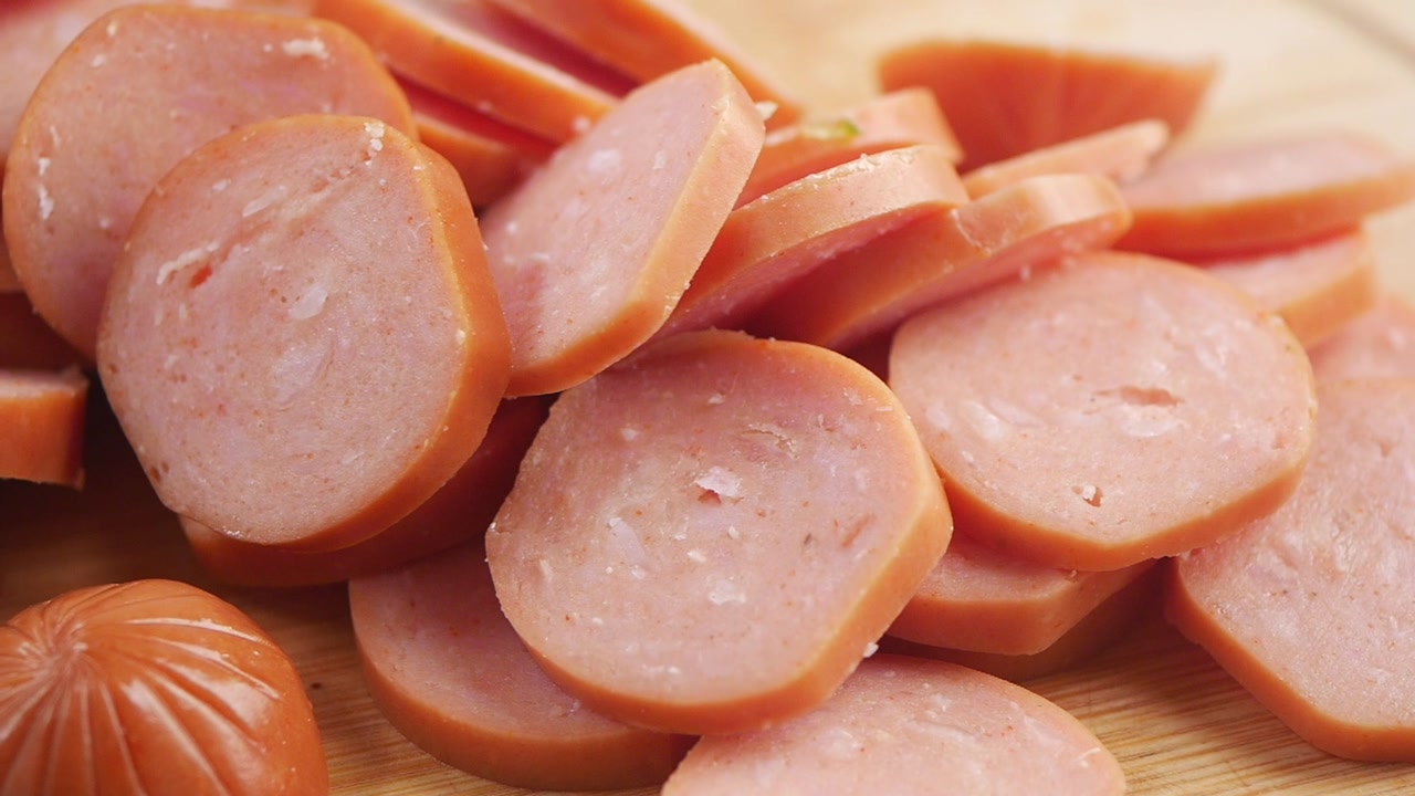 Close-up of Sliced Hot Dogs on a Wooden Cutting Board