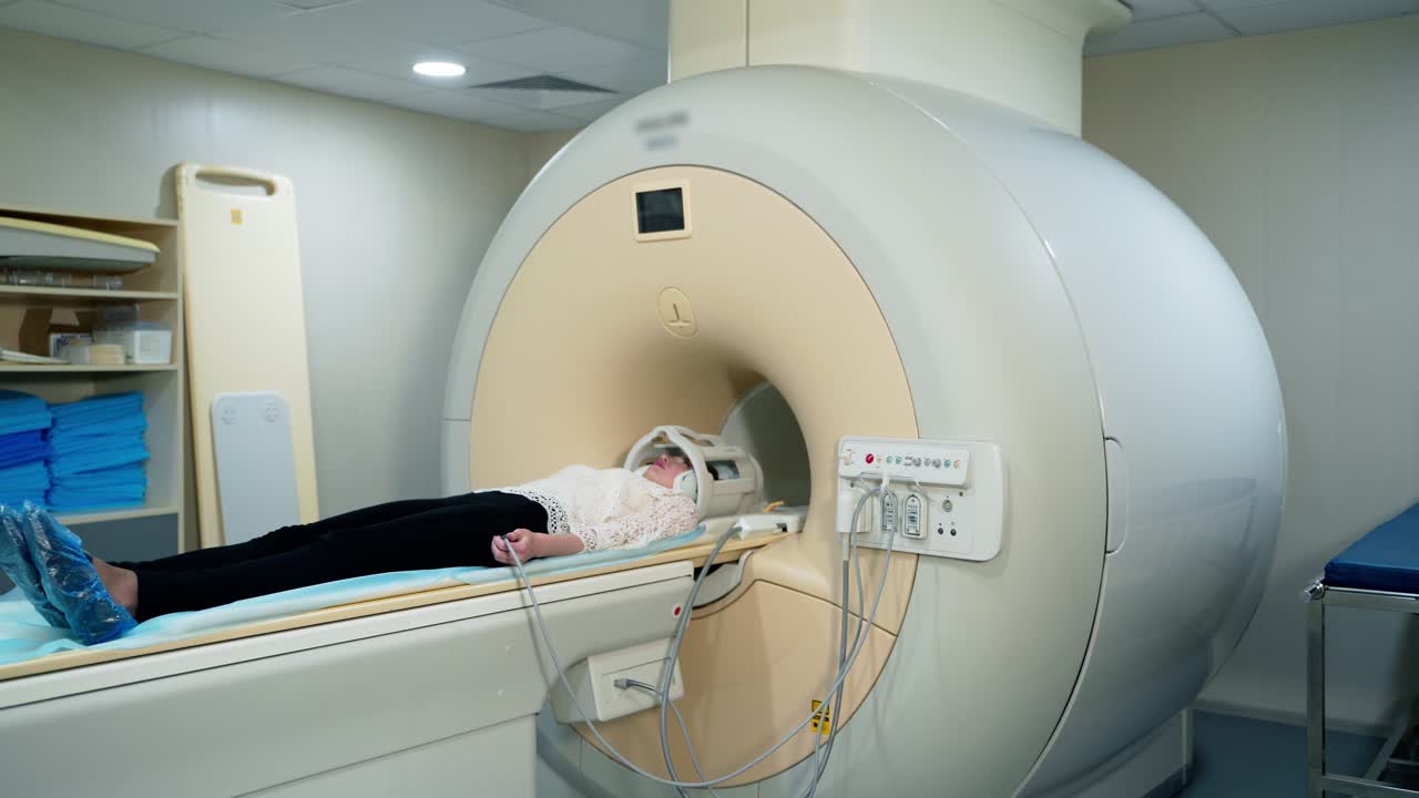 Patient in a hospital MRI scanner. Woman lays in Magnetic resonance image device. Woman patient is doing tomographic scanning in clinic.
