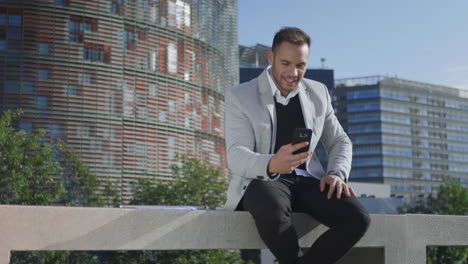 Close-up-smiling-businessman-having-video-chat-on-smartphone-at-street