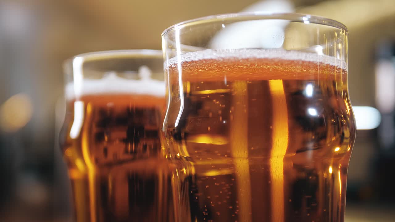 Primo piano di due birre dorate con schiuma nel bicchiere