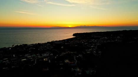 Paisaje-Del-Atardecer-Sobre-El-Océano-Y-Un-Pueblo-En-Grecia:-Fotografía-Aérea-Con-Dron